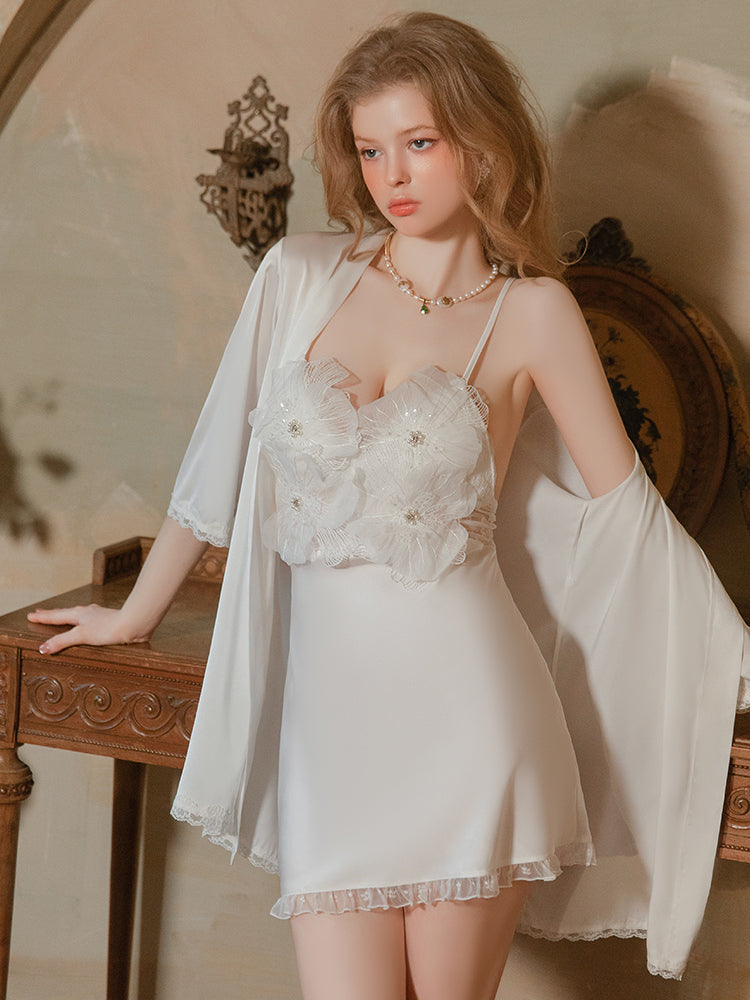 Woman in a white lace nightgown standing in a softly lit room. white mini dress floral applique slip dress cross back babydoll nightgown matching robe white lingerie sheer mesh.