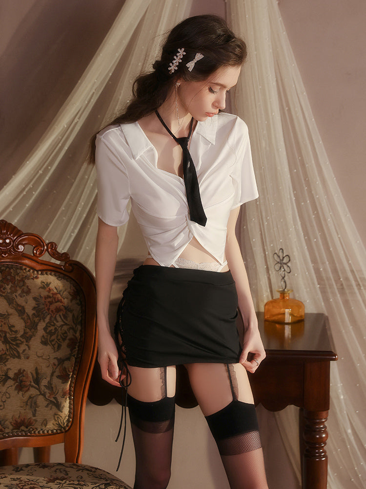 Woman in a white shirt and black skirt standing in a room with draped fabric and a chair.