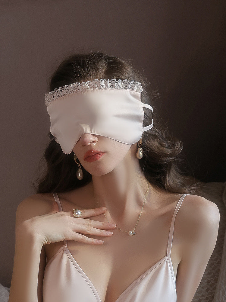 Woman wearing a pink Lace Trim Satin Sleep Mask Blindfold against a dark background