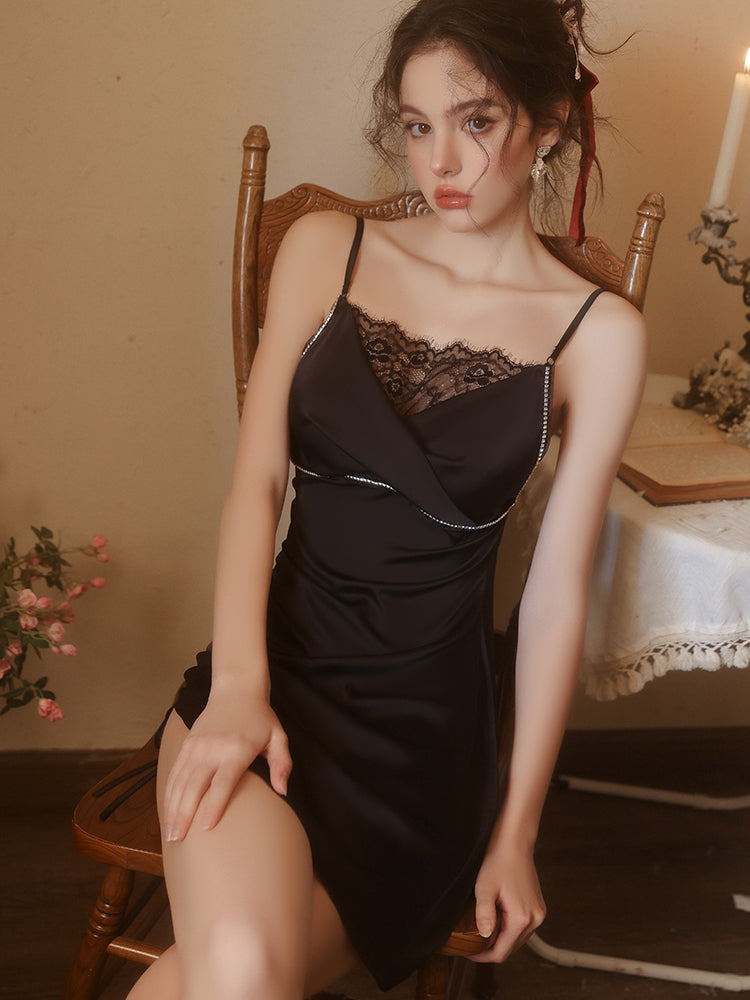 Woman in a black lace dress sitting on a wooden chair in a warm-toned room.