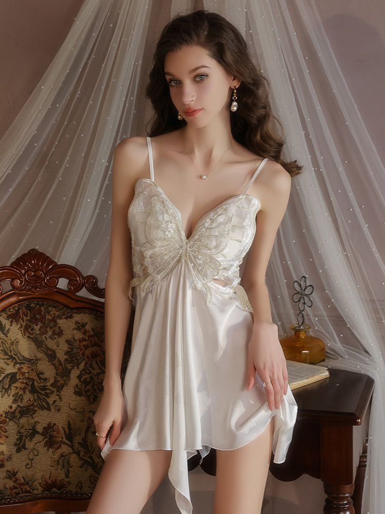 Woman wearing a white Butterfly Lace Appliqué Satin Slip Dress with lace details in a softly lit room.