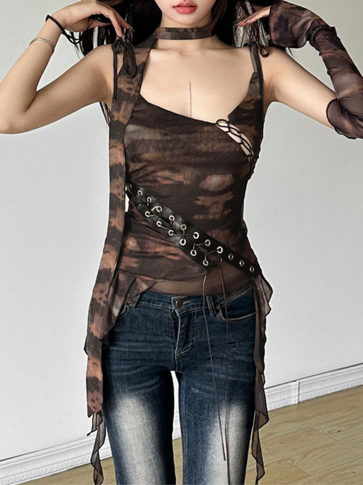 Person wearing a sheer brown top with cut-out design and dark jeans against a plain background