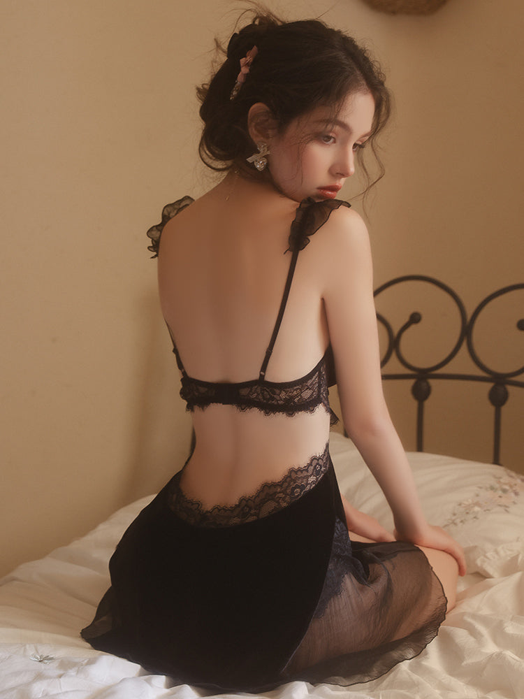 Woman wearing a black Lace Corset Bodice Velvet Slip Dress sitting on a bed.