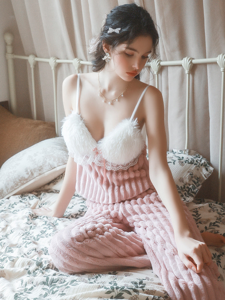 Woman in a pink and white Textured Knit Plush Pink Pajama Set sitting on a bed.
