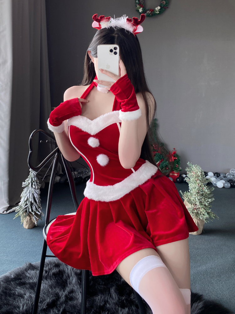 Velvet mini costume dress styled with fur details and a halter neckline, captured in a festive backdrop with seasonal decor.