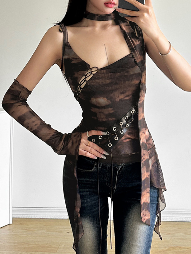 Person wearing a sheer brown top with long sleeves and a black belt, standing against a white wall.