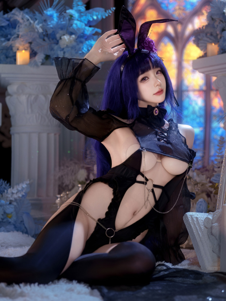 Person in a Black Sheer Lace Cutout Bunny Costume Sexy Lingerie Bodysuit with bunny ears in a decorative setting.