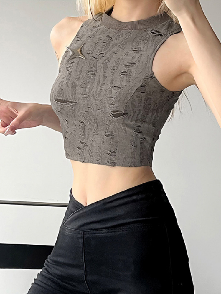 Person wearing a gray textured crop top and black pants on a plain background
