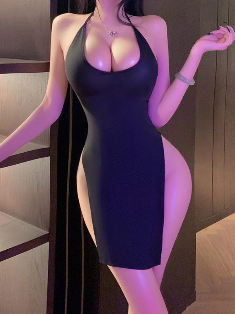 Woman wearing a black dress with a high slit in a dimly lit room.