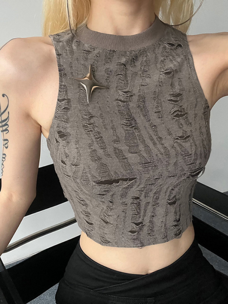 Person wearing a textured gray crop top with a star-shaped brooch.