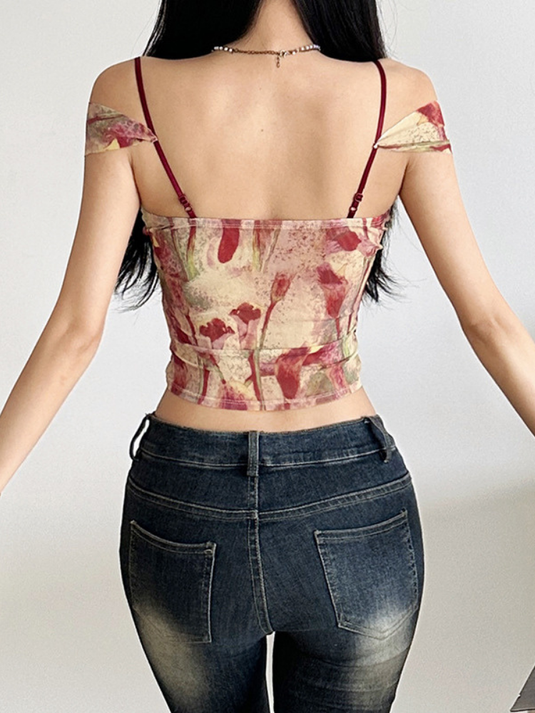 Person wearing a floral top and jeans on a plain background