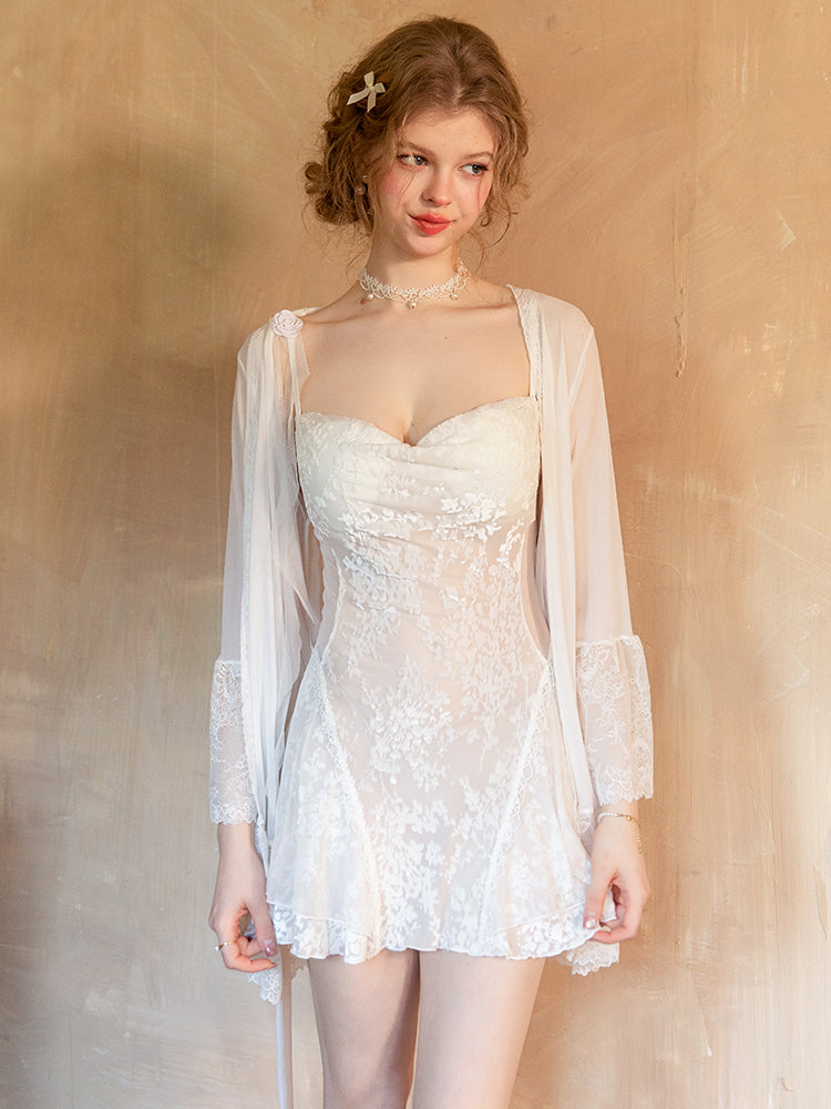 Woman wearing a white lace dress with a sheer overlay against a beige background white babydoll dress, mini dress, floral embroidered dress, sheer lingerie, white lingerie, chemise nightgown, mini slip dress