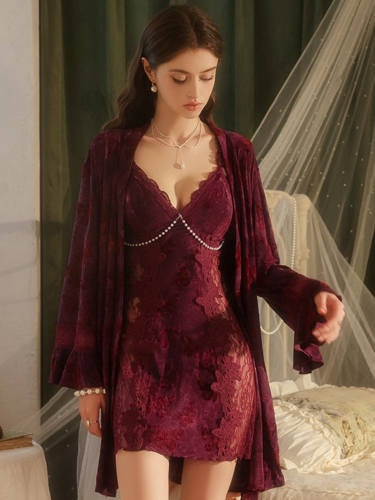 Woman wearing a burgundy lace nightgown with a matching robe in a bedroom setting.