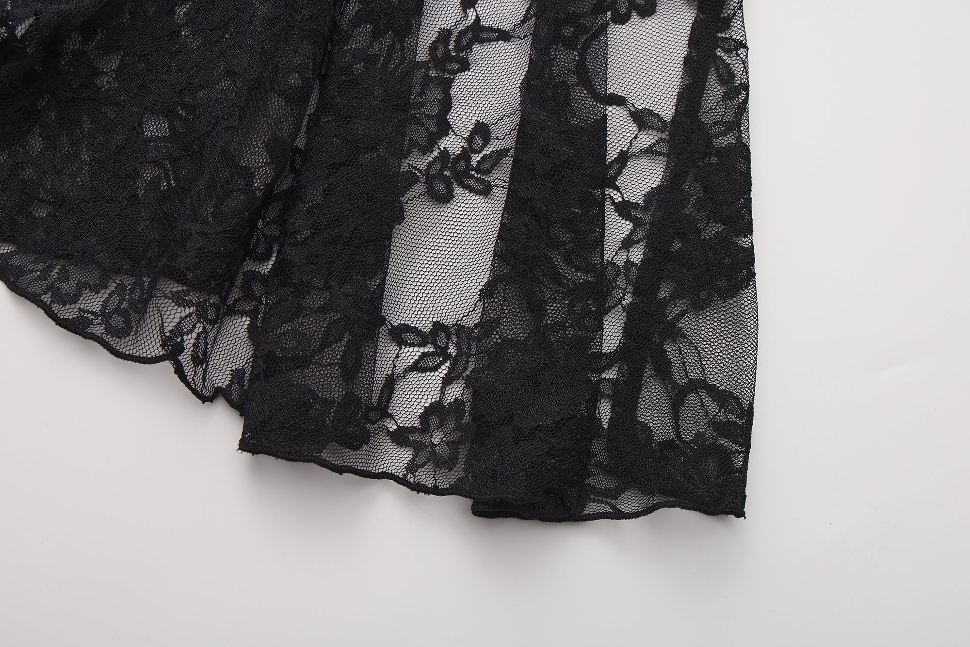 Black lace fabric on a white background