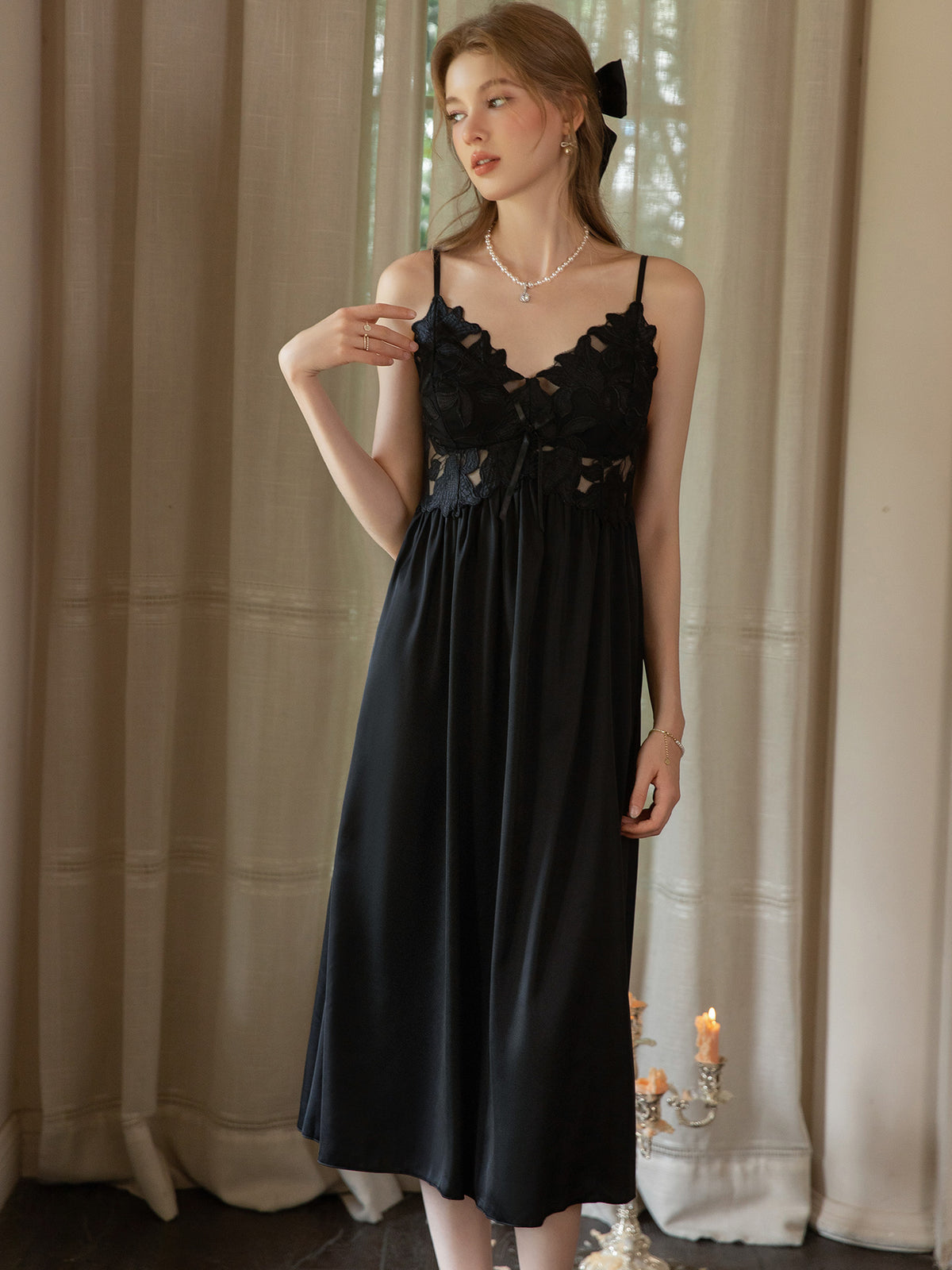 Black sleeveless satin midi slip dress front view showing gathered empire seam and loose skirt