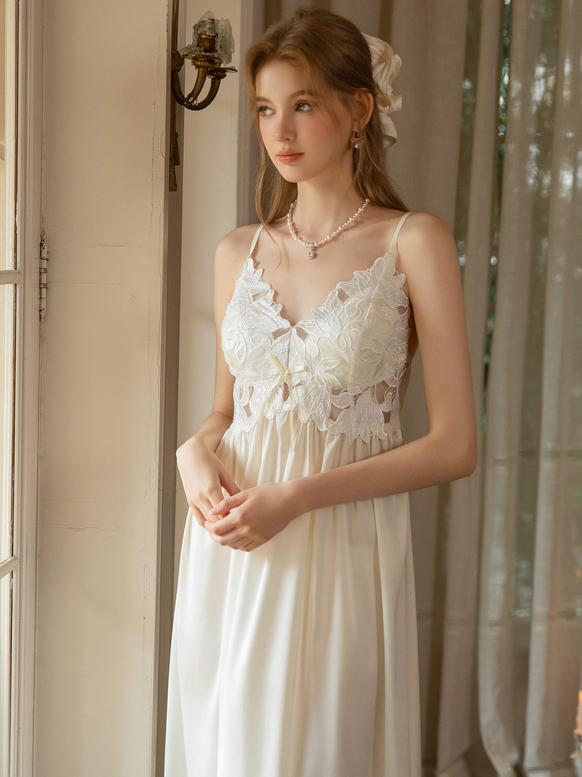 White satin slip dress bodice detail showing floral guipure lace, front bow and spaghetti straps