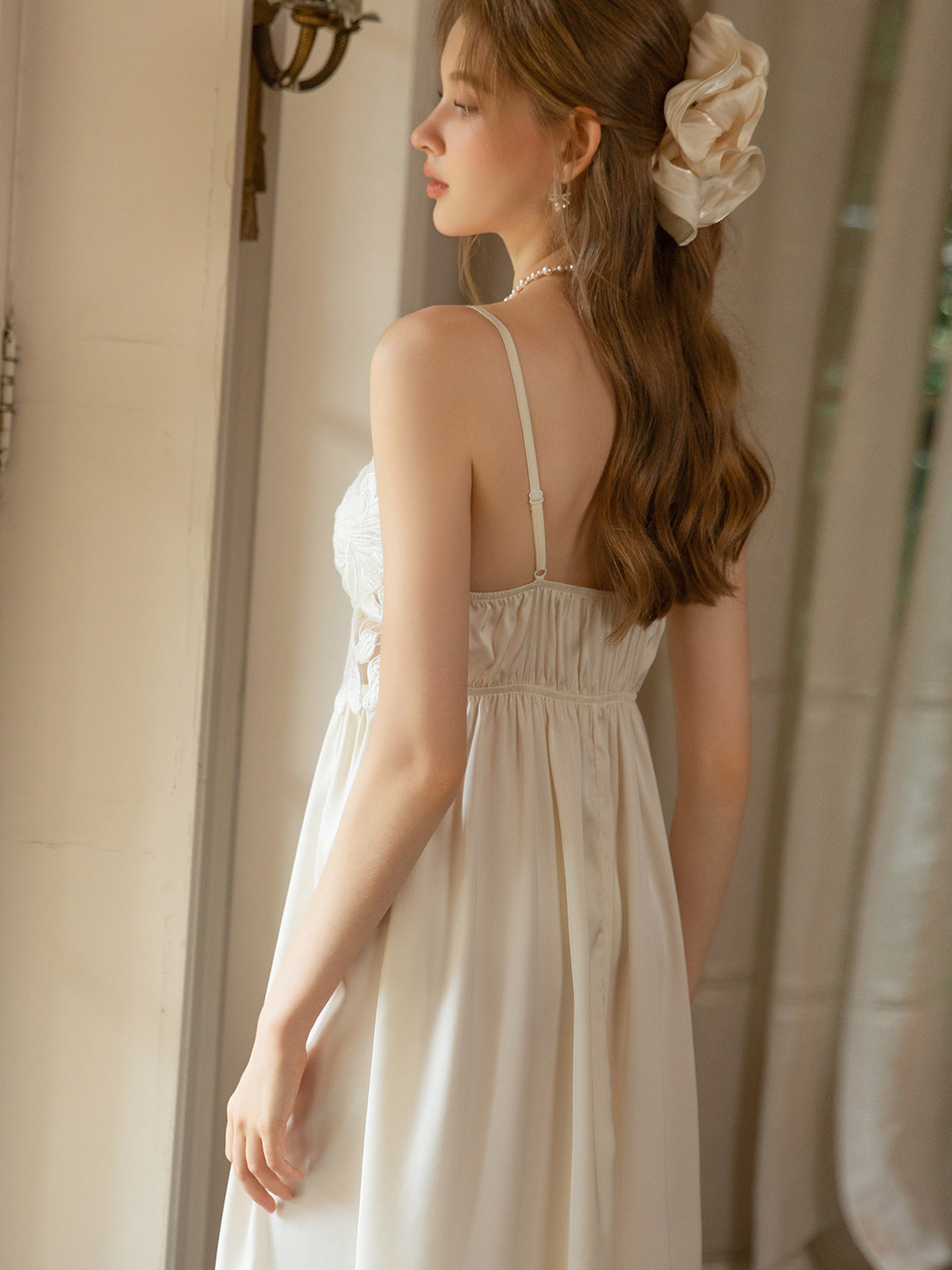 White satin slip dress rear view showing adjustable spaghetti straps and gathered back