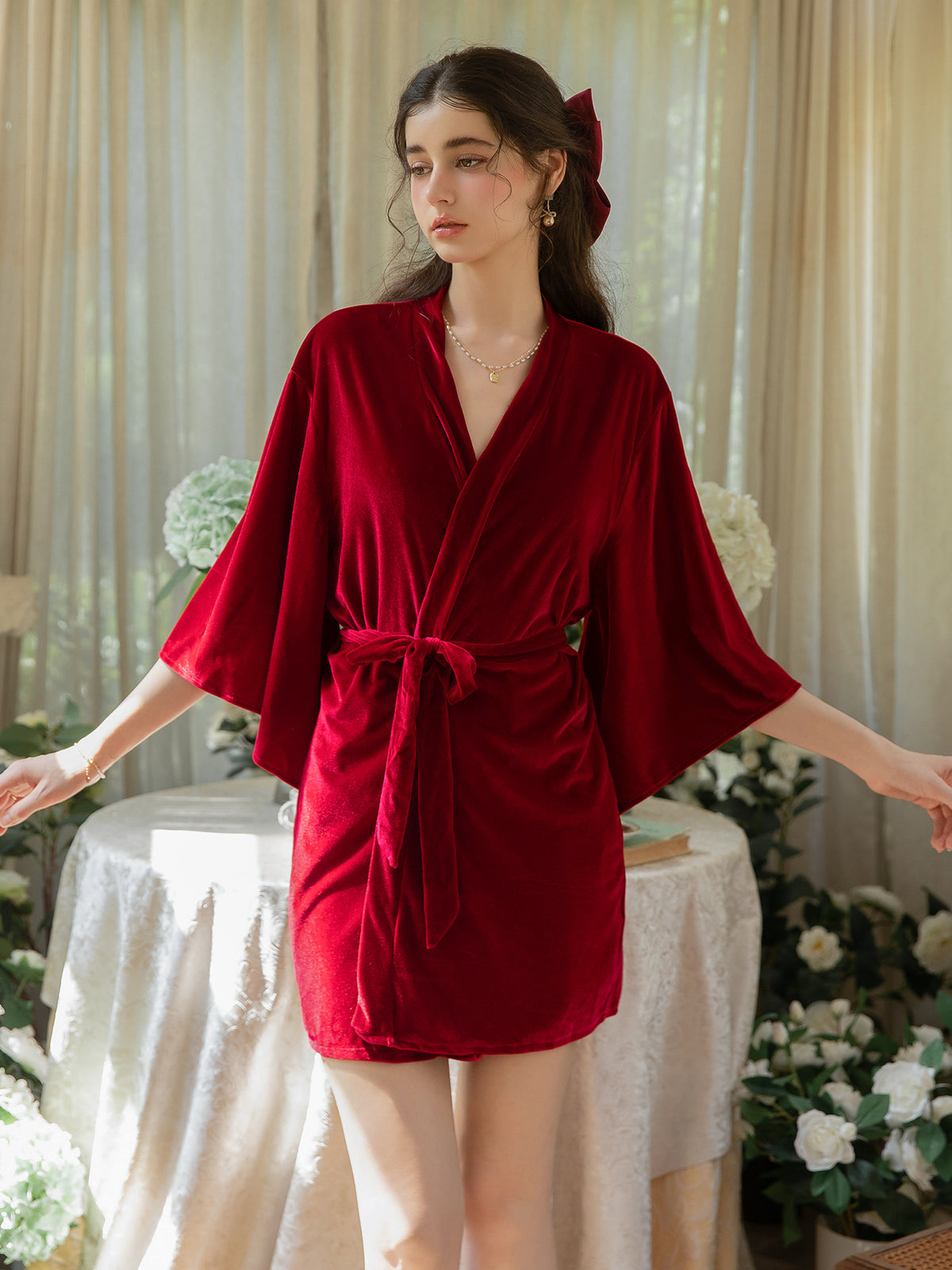 Red short velvet robe front view showing wrap neckline, tie belt and wide sleeves