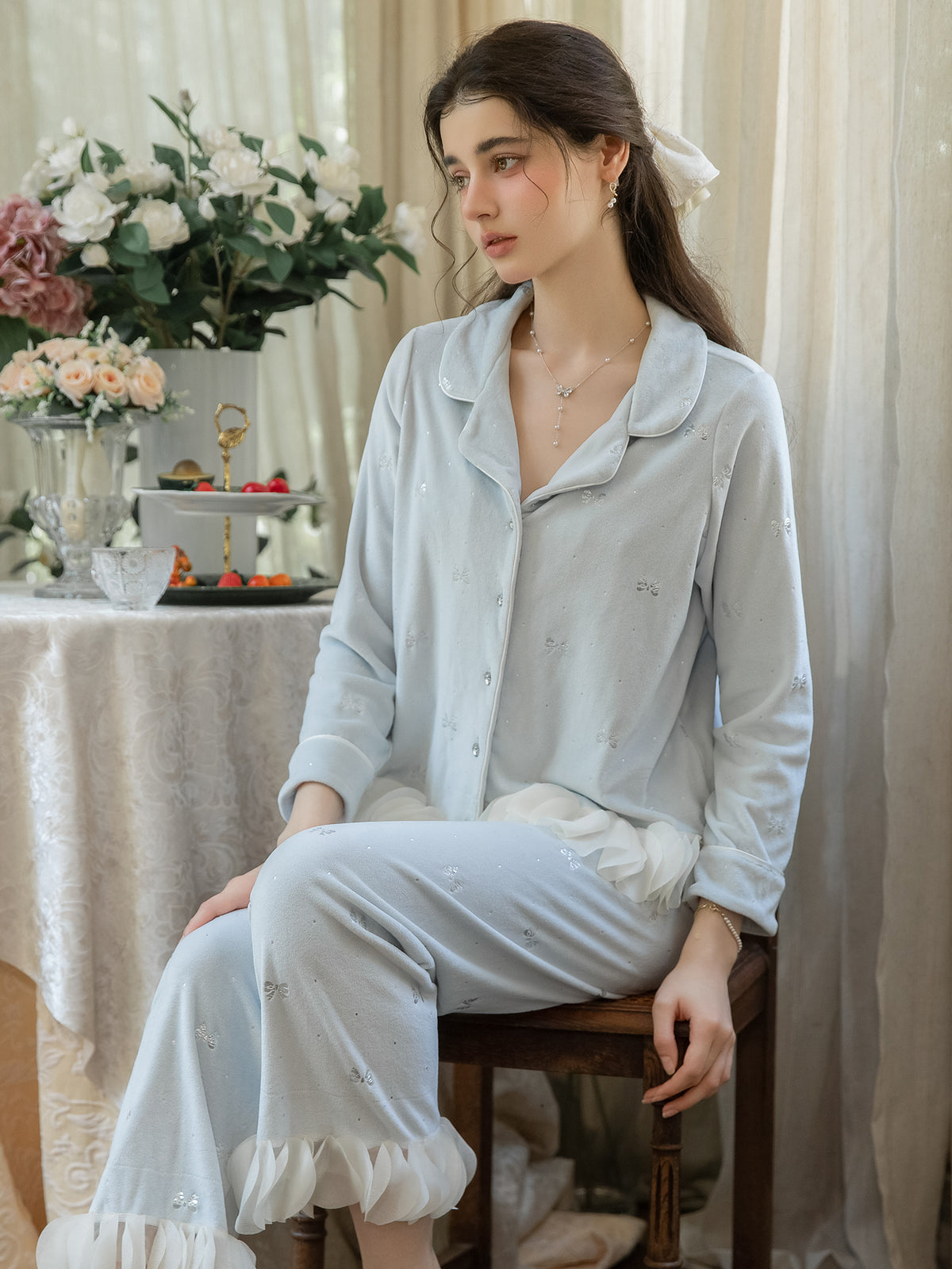 Light Blue button front sleep jacket and bow print pajama pants seated view