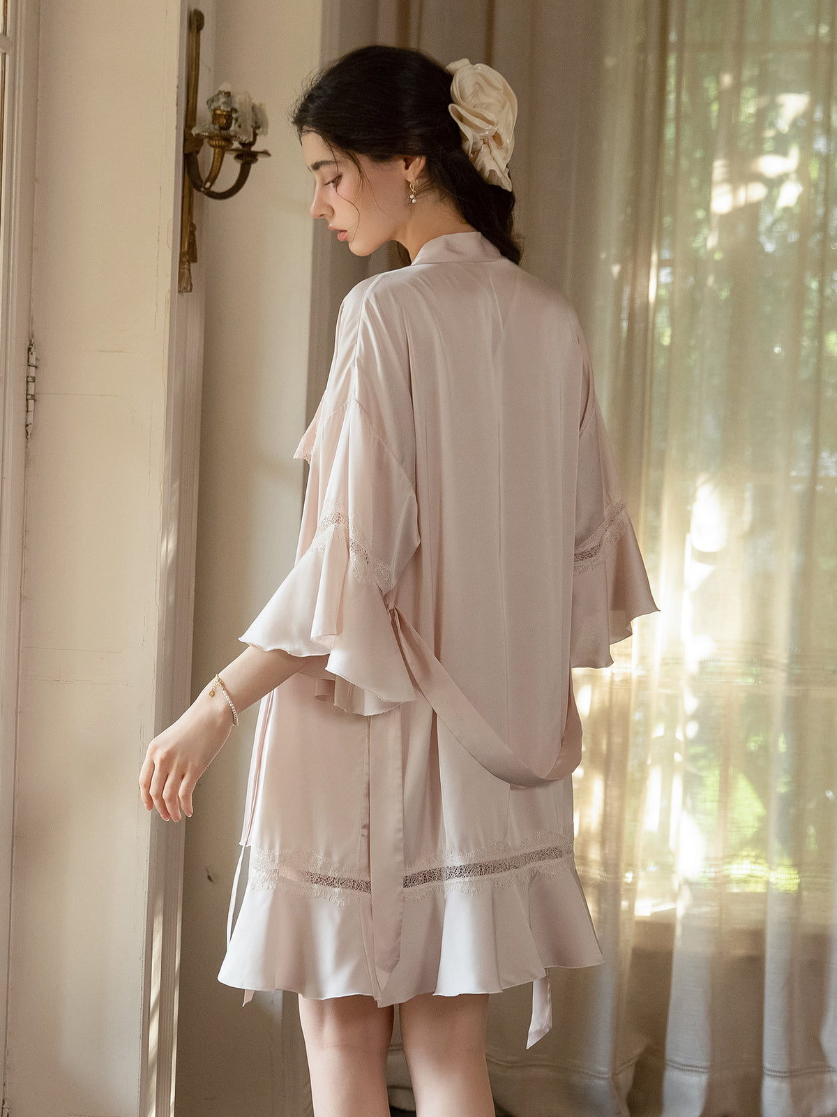 Rear view of pink satin Robe showing waist tie and ruffle hem