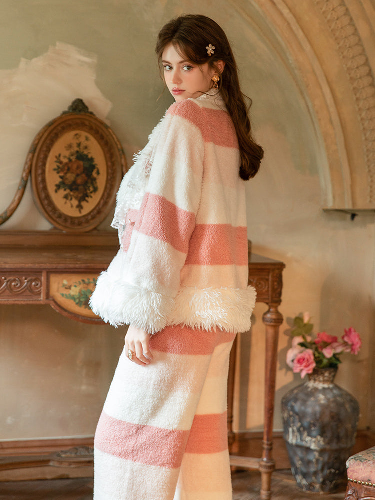 Woman wearing a pink and white Pink Plush Stripe Fleece Pajama Set in an elegant room with decorative elements.
