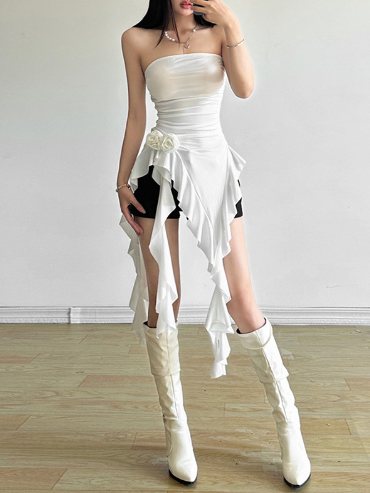 Full body view of a white strapless layered dress with a ruffled hem and ruched bodice, styled with matching white knee high boots