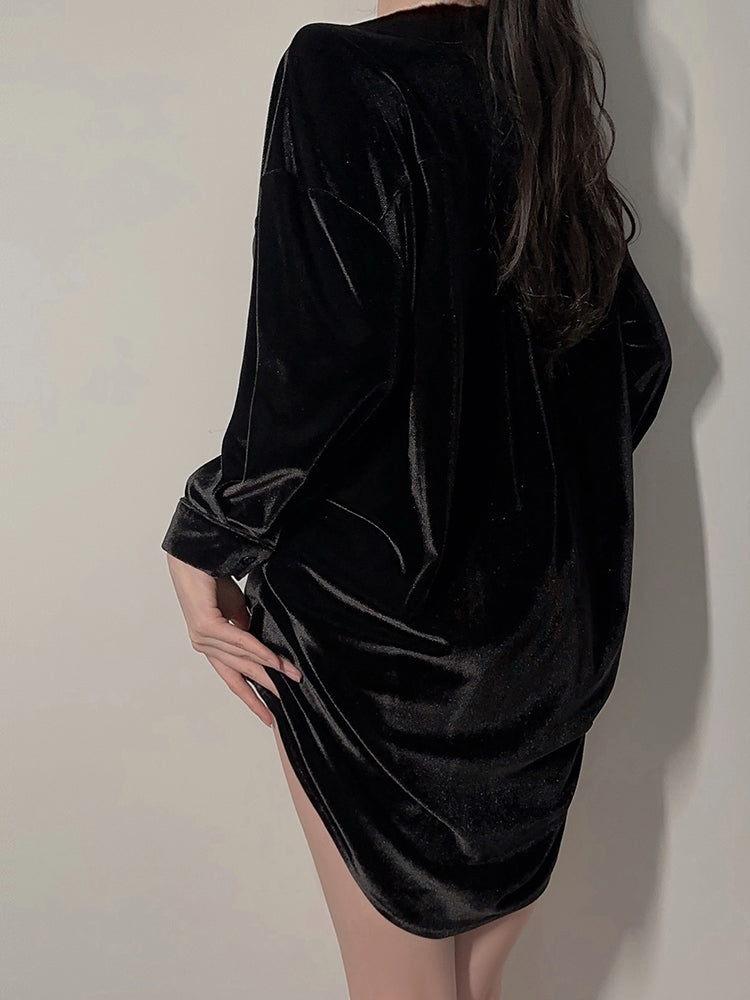 Back view of model standing in black velvet button down shirt dress with rounded hem design 