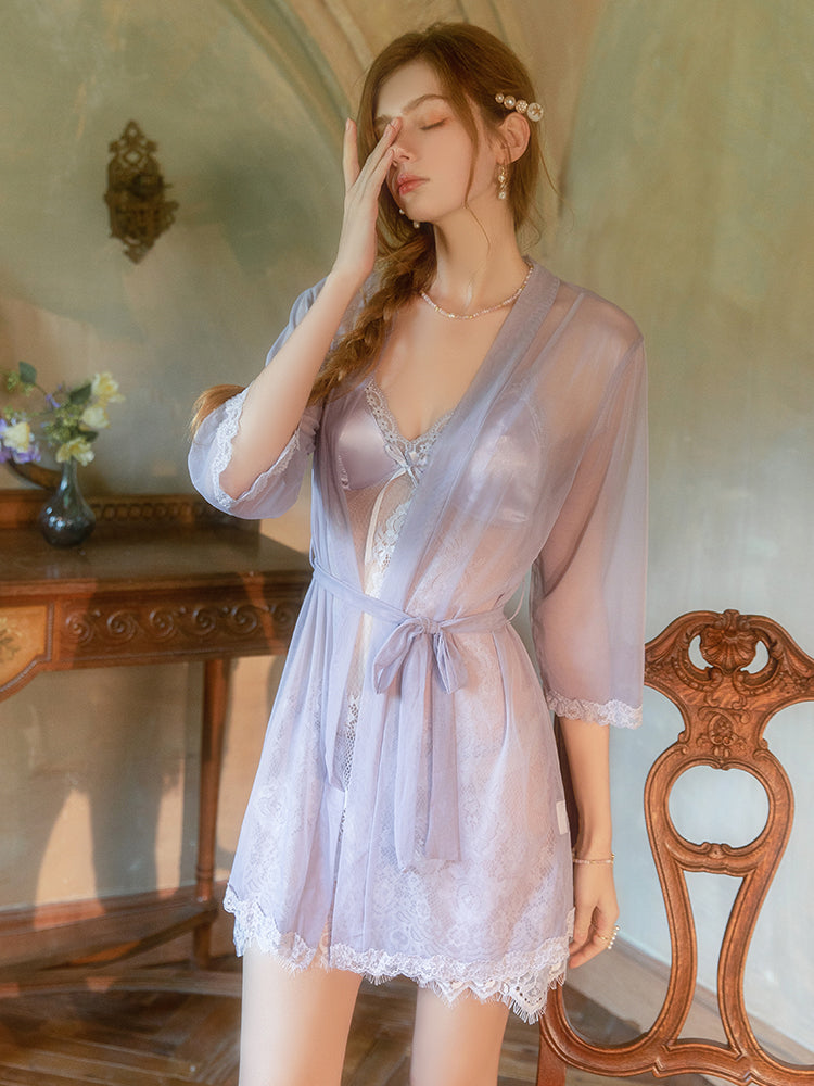 Woman in a sheer pink robe standing in a vintage room.