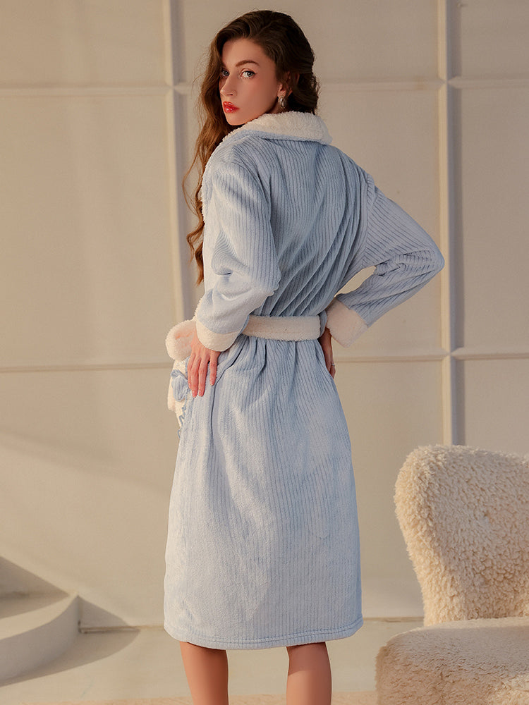 back view of sky blue textured plush robe set with bow pocket embellishments and sherpa lining modeled in an elegant setting - Plush Textured Robe Set with Bow Pocket Details.