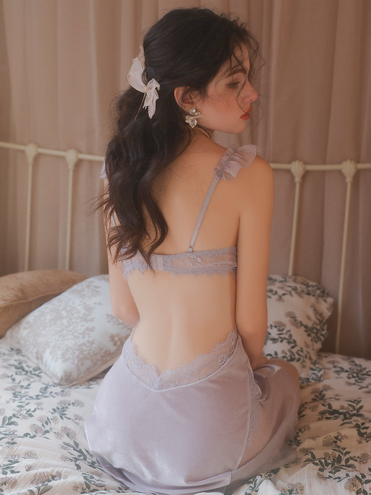 Woman in a light purple Lace Corset Bodice Velvet Slip Dress sitting on a bed with a neutral background