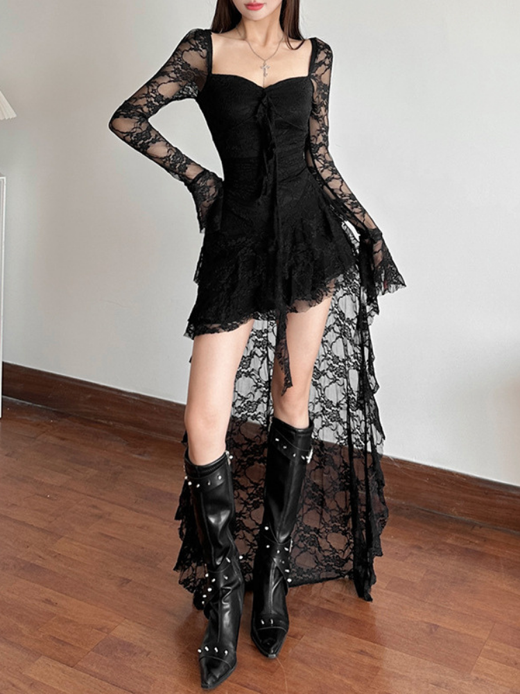 Woman wearing a black lace dress and boots on a wooden floor.