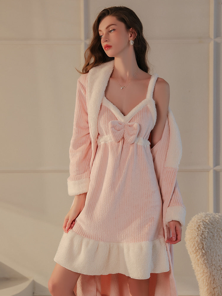 A pink slip dress with a bow detail and plush fleece hemline, styled as part of the textured robe set, model holding the robe casually.