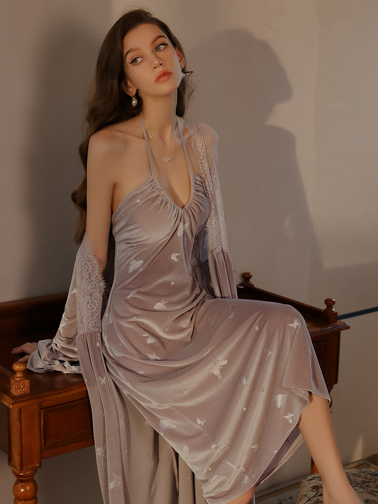 Woman in a halter-neck butterfly print lavender dress seated on desk