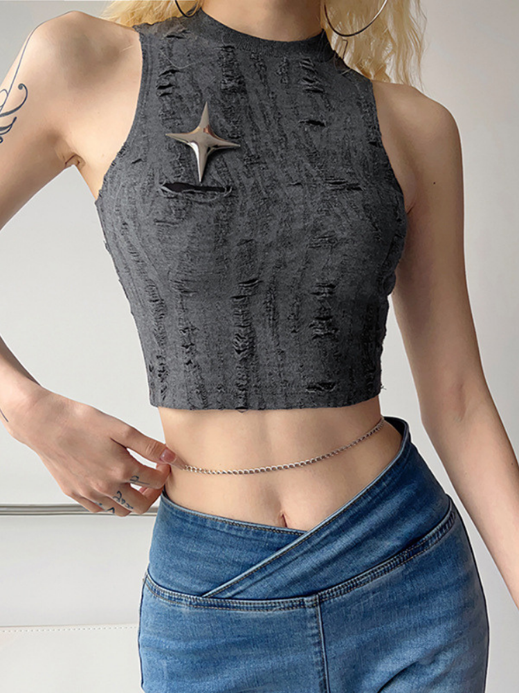 Person wearing a gray distressed crop top and blue jeans on a plain background
