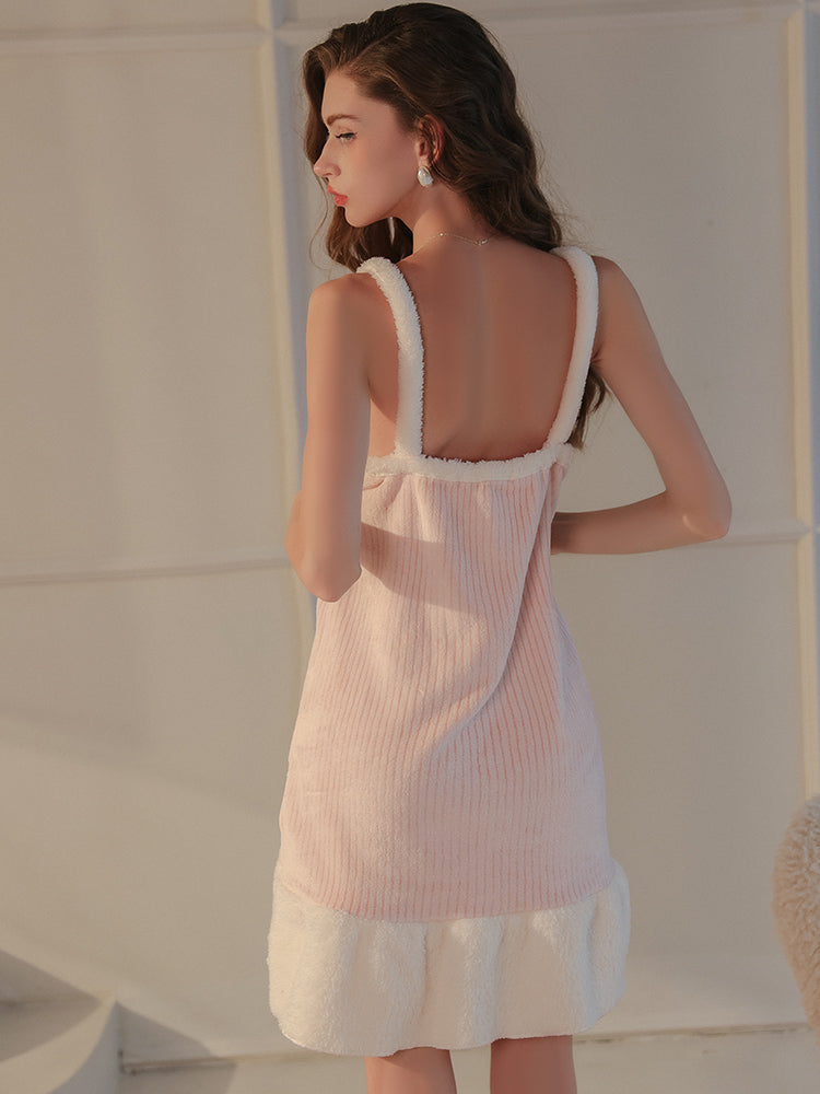 A back view of a pink plush textured robe set with wide straps and a flared hemline, model showcasing its flowy design.