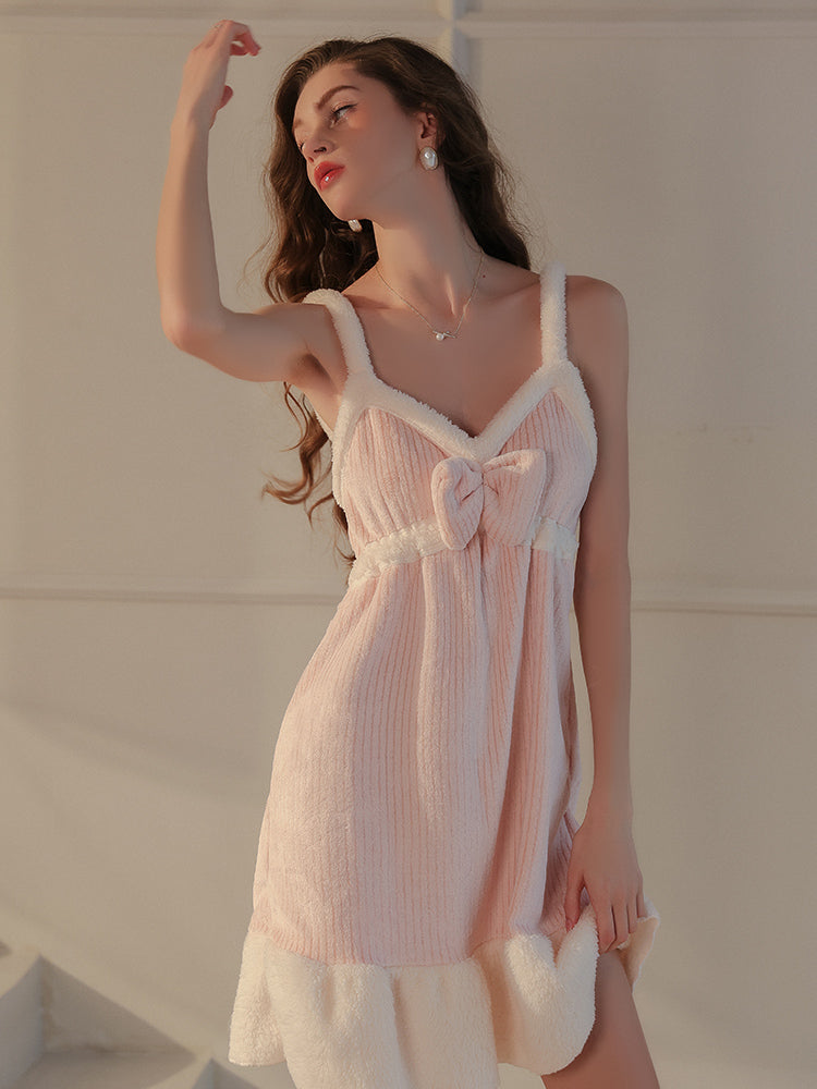 A pink plush textured robe set showcasing the V neck slip dress with a bow embellishment, model standing in a side pose