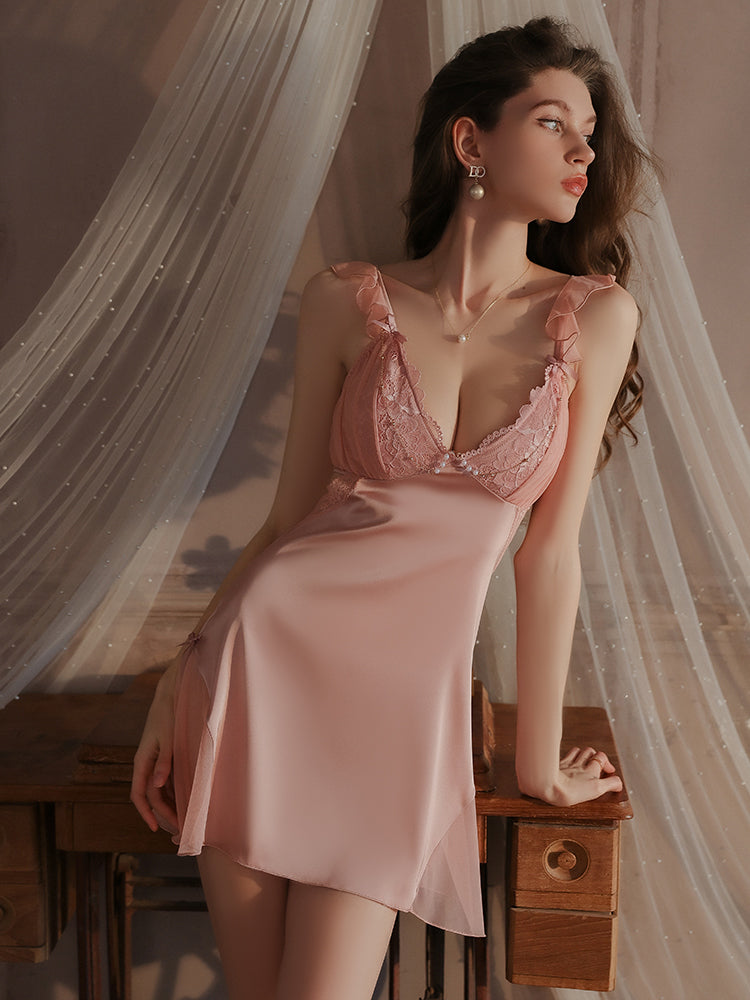 Side view of pink lace ruffle strap slip dress showcasing adjustable ruffle straps, soft satin finish, and intricate lace detailing in a cozy setting.