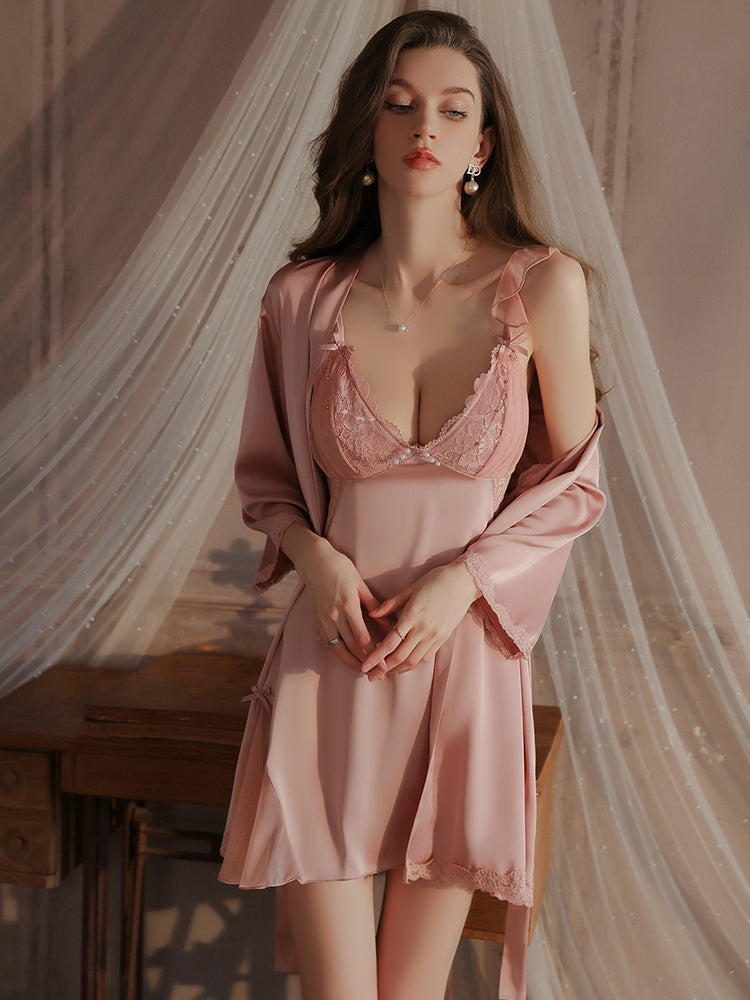 Pink lace ruffle strap slip dress with soft satin texture, adjustable ruffle straps, and sheer lace accents, styled with a matching robe in a romantic setting.