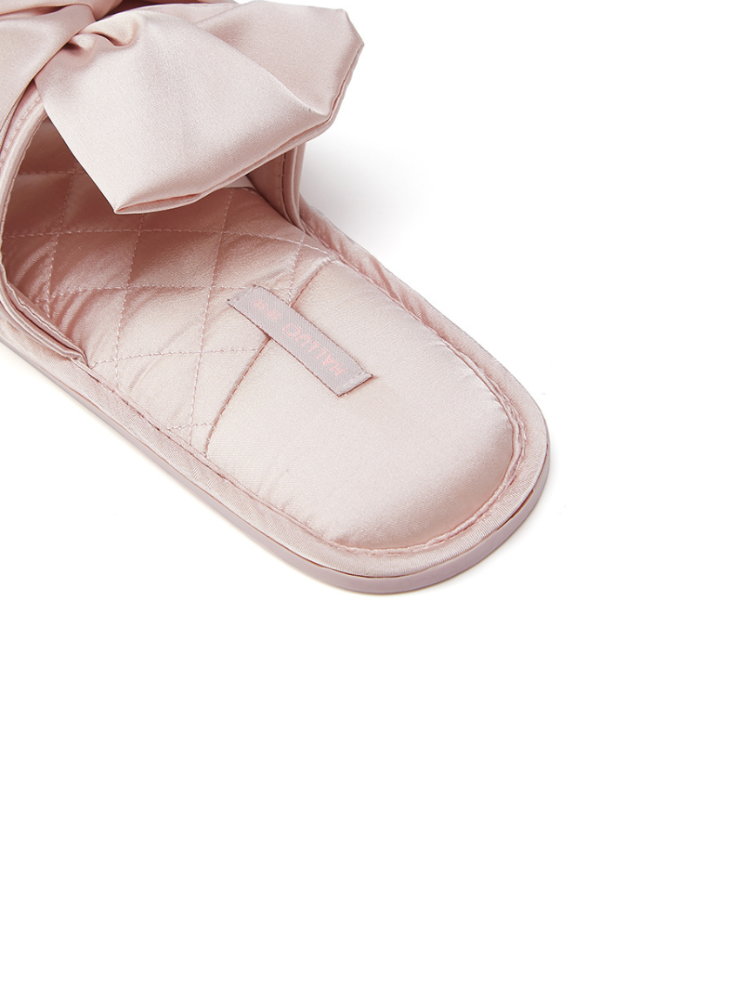 Pink satin bow quilted slippers close-up front view soft satin fabric