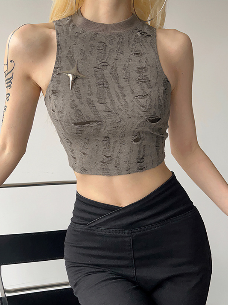Person wearing a textured gray crop top and black pants on a neutral background