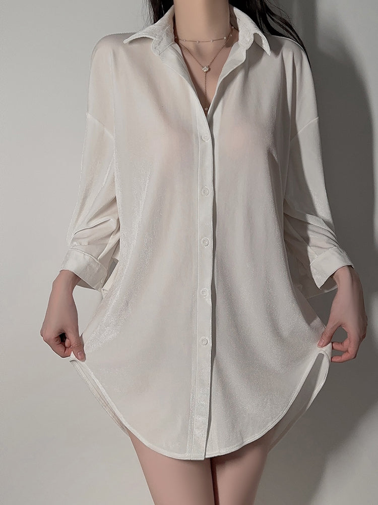 Model holding edges of white velvet button down shirt dress standing view