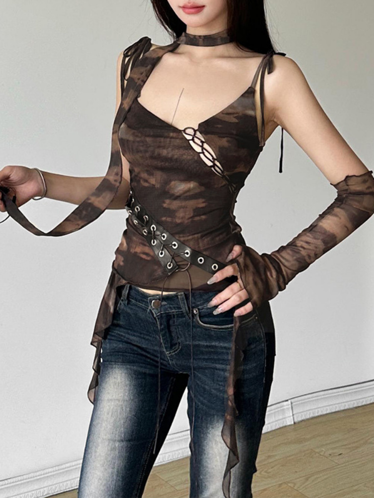 Woman wearing a brown sheer top with long sleeves and dark jeans against a white background