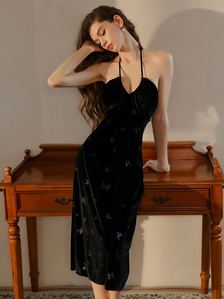 Black butterfly velvet dress standing side view near wooden table