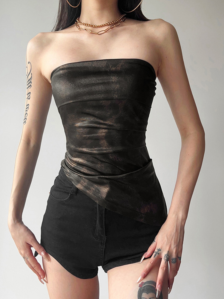 Woman wearing a black strapless top and shorts on a plain background