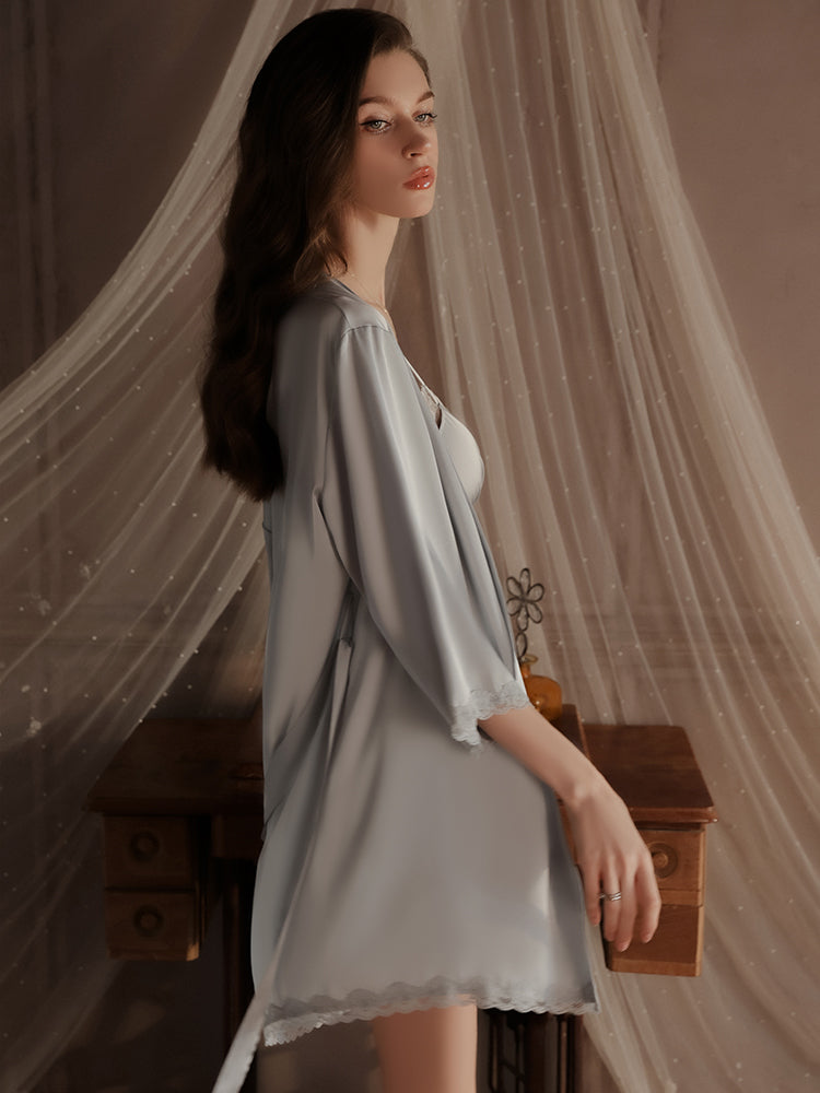 Side profile of a model in a light blue satin robe with lace trimmed sleeves, styled over a matching satin babydoll dress, creating a soft and romantic look.