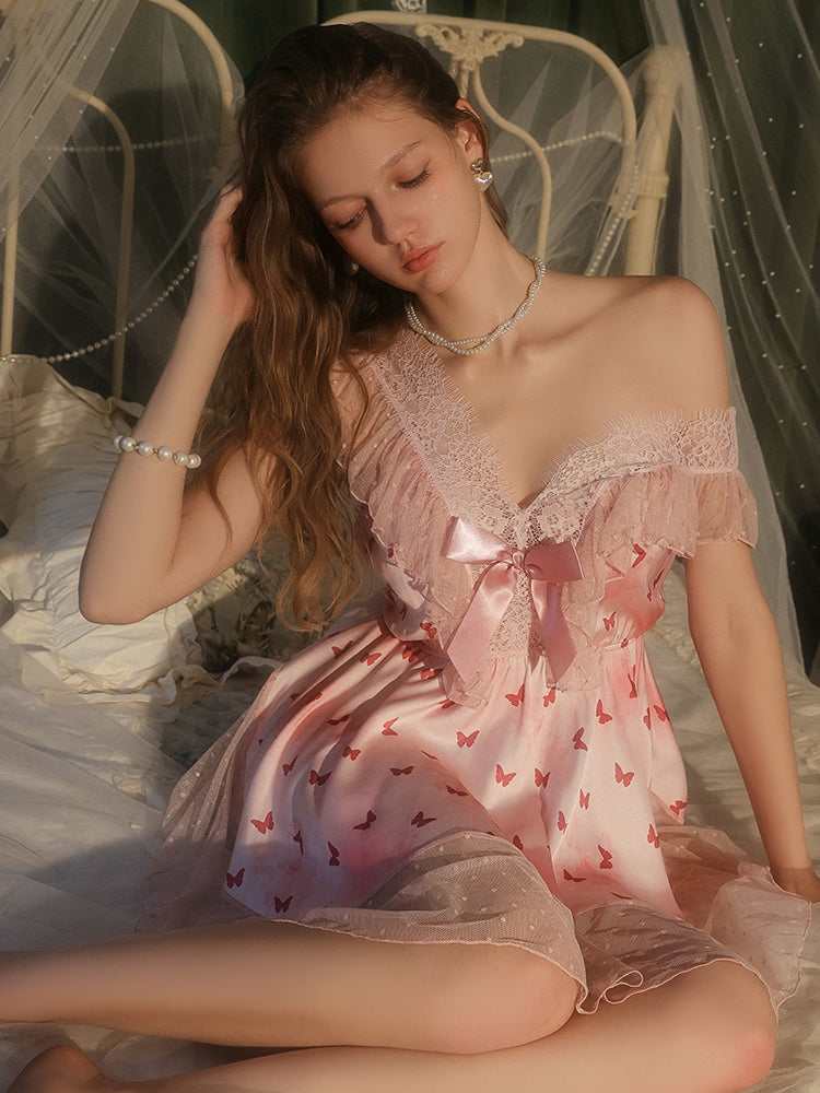 Woman in a pink dress with butterfly patterns sitting on a white chair.