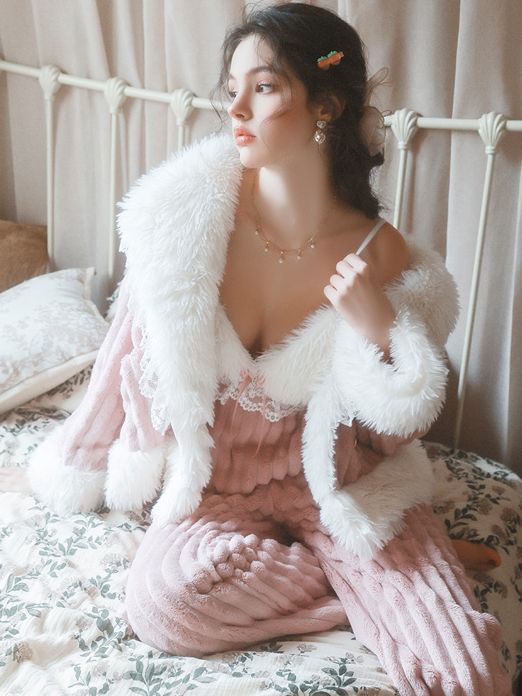 Woman in a Textured Knit Plush Pink Pajama Set with a white fluffy jacket sitting on a bed.