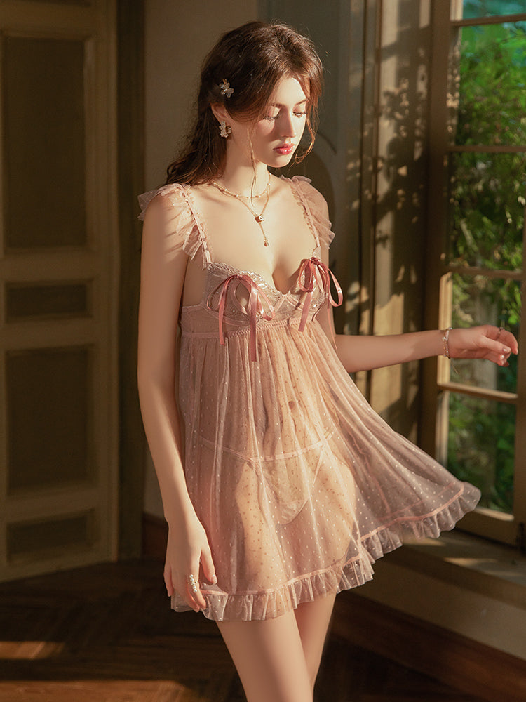 Woman wearing a light pink Sheer Dotted Mesh Babydoll Nightgown in a softly lit room.
