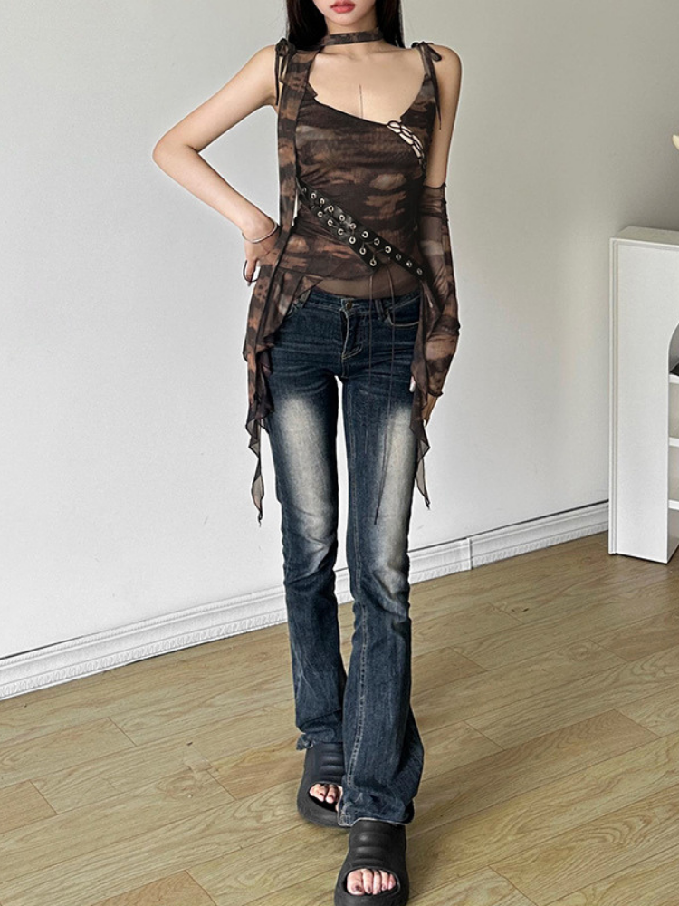 Person wearing a sheer top and jeans in a minimal indoor setting