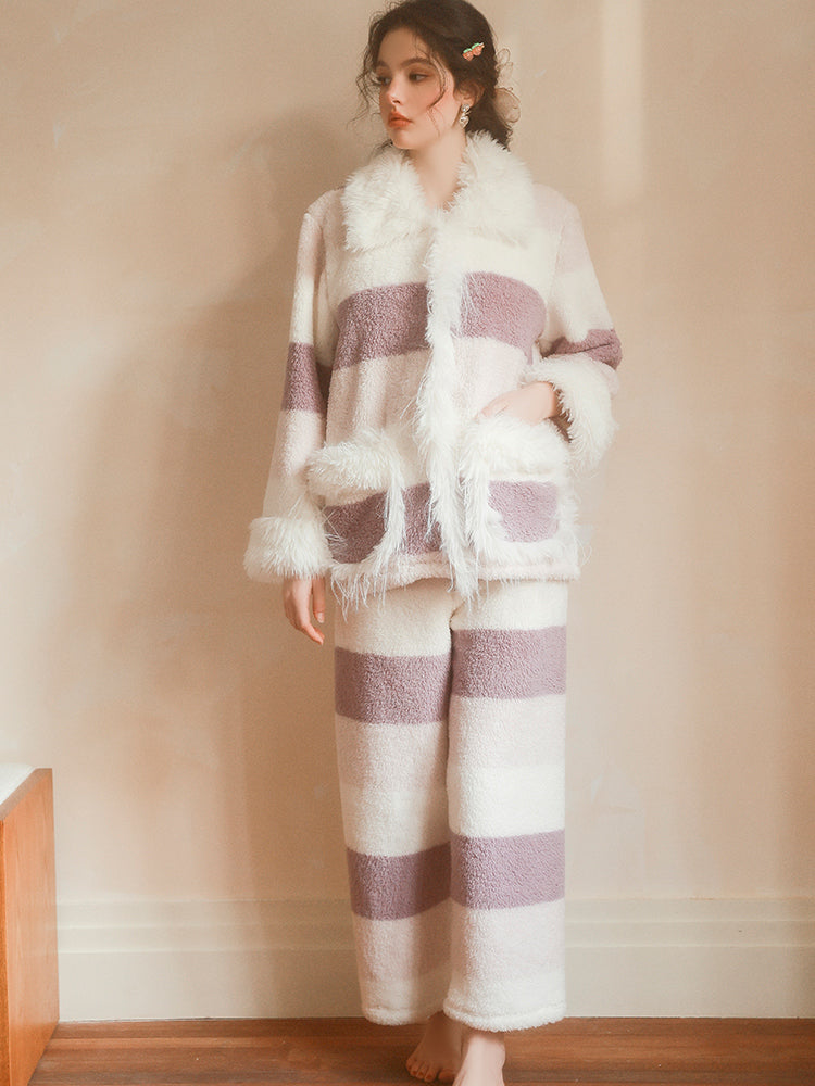 Person wearing a white and purple striped outfit with a matching blanket in a room.